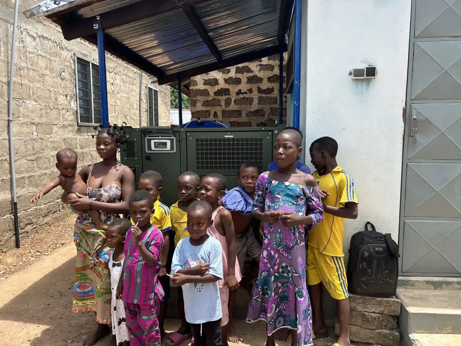 Des enfants et leurs mères devant le générateur d'eau AirLife
